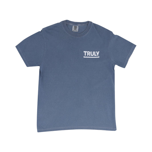 A blue short-sleeve t-shirt with "TRULY" printed in white block letters above a white line on the left chest area.