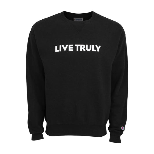 A black crewneck sweatshirt with "LIVE TRULY" printed in white bold letters across the chest and a small red and blue Champion logo on the left cuff.