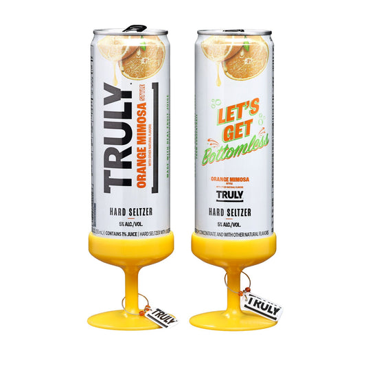Two tall, slim cans of Truly Hard Seltzer Orange Mimosa, each with a yellow base shaped like the bottom of a stemmed glass, on a white background. The left can has "TRULY ORANGE MIMOSA" text and the right can has "LET'S GET bottomless" text.