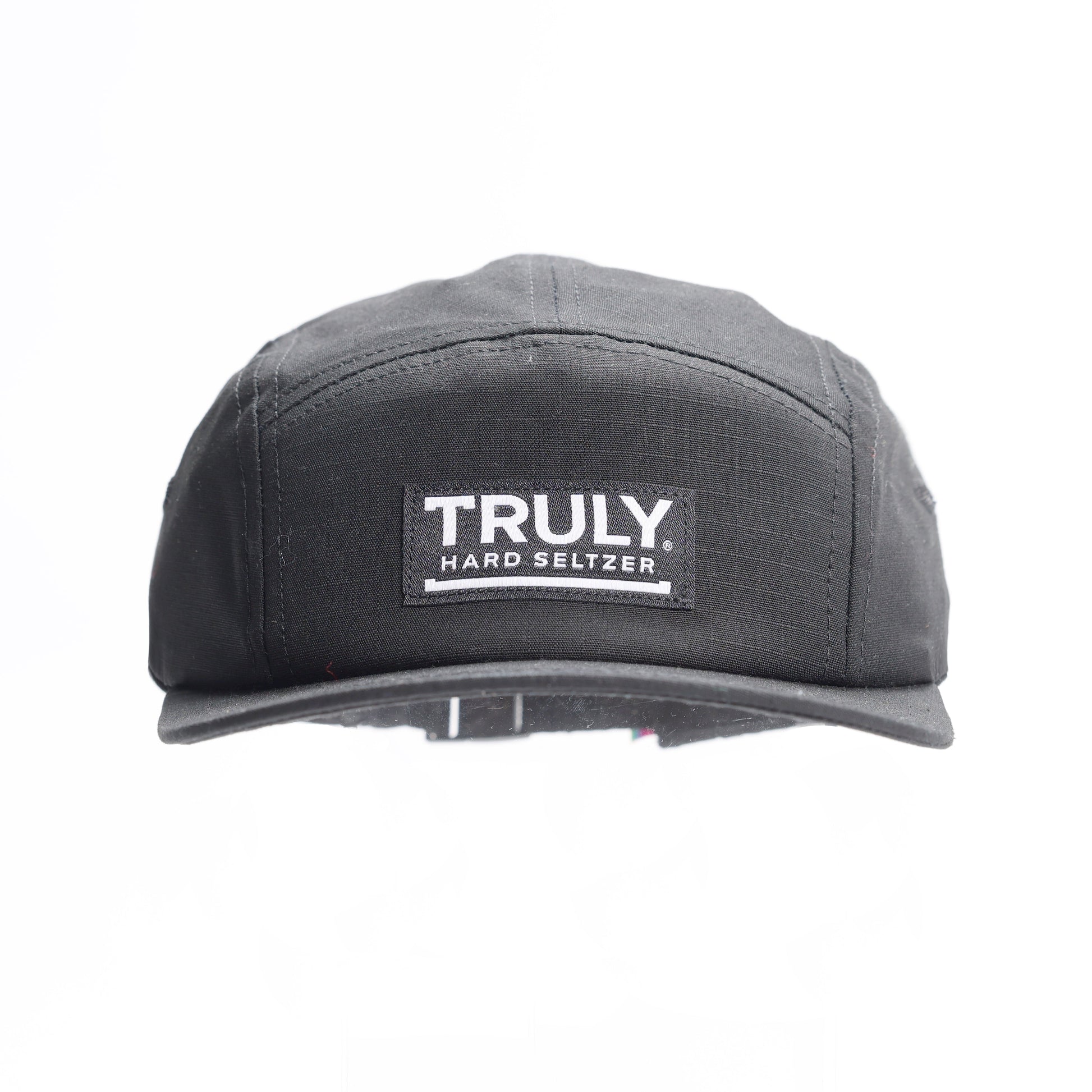 A black five-panel baseball cap with a flat brim. A rectangular patch on the front reads "TRULY HARD SELTZER" in white text.