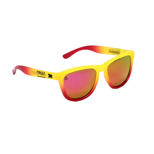 Yellow, pink ombre sunglasses with Truly logo shown on the right side in black.