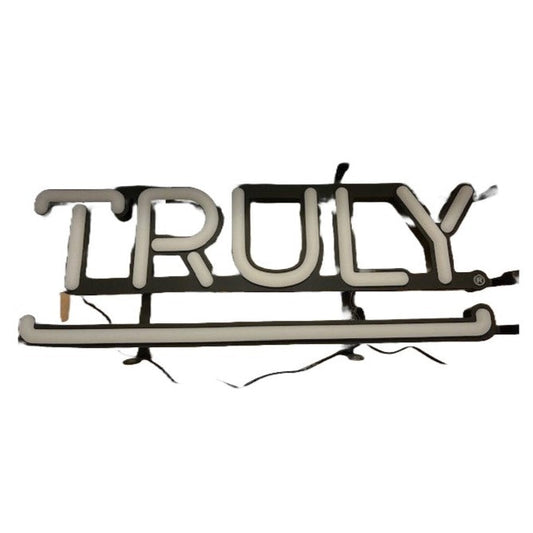 A white Truly-branded LED sign with the word "TRULY" illuminated in white, featuring black outlines and exposed wires.