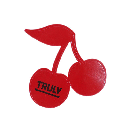 Two red cherry-shaped tanning stickers. The left cherry has the word "TRULY" printed in black text across it.