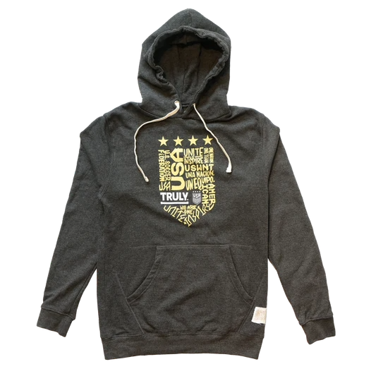 Emblem with assorted words including, "USA", "Truly", "Unite", "Inspire", and more. It is in the shape of a soccer shield crest. Above it are four gold stars.